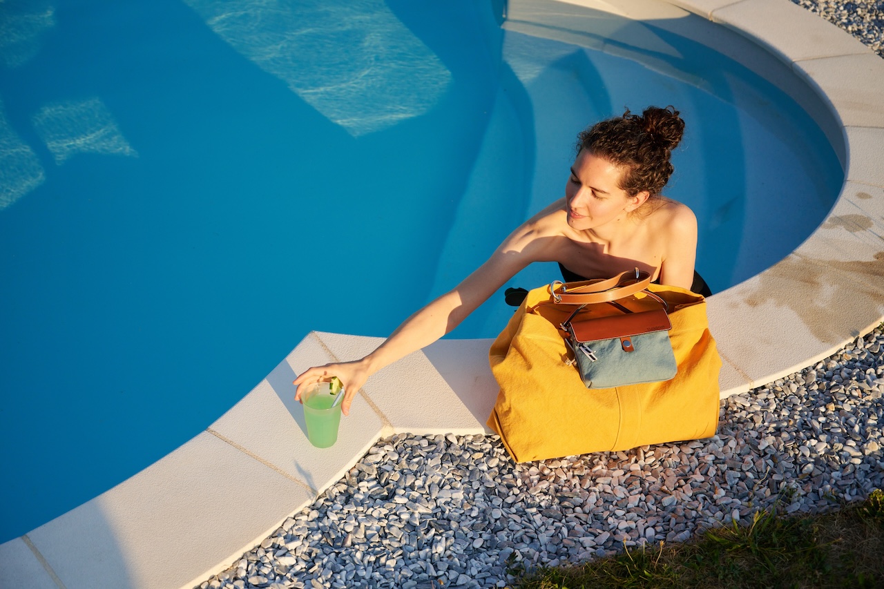 Mannequin dans une piscine avec sac jaune au bord