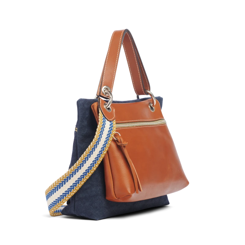 pochette yole en cuir naturel gold accrochee sur un equipier marine avec une anse canotage et une sangle tribal pain d'epice