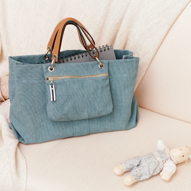 sac de ville modulable en coton bleu français avec des anses en cuir naturel et ses pochettes yole en cuir gold et en coton bleu canard